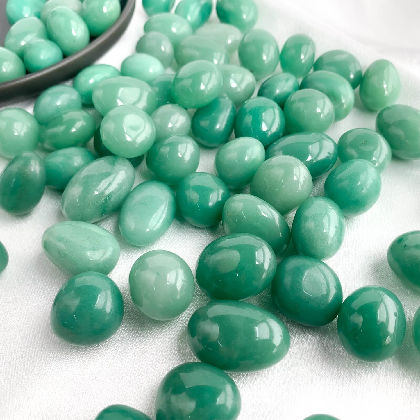Variety of smooth green aventurine pocket gems, known for attracting luck and prosperity.
