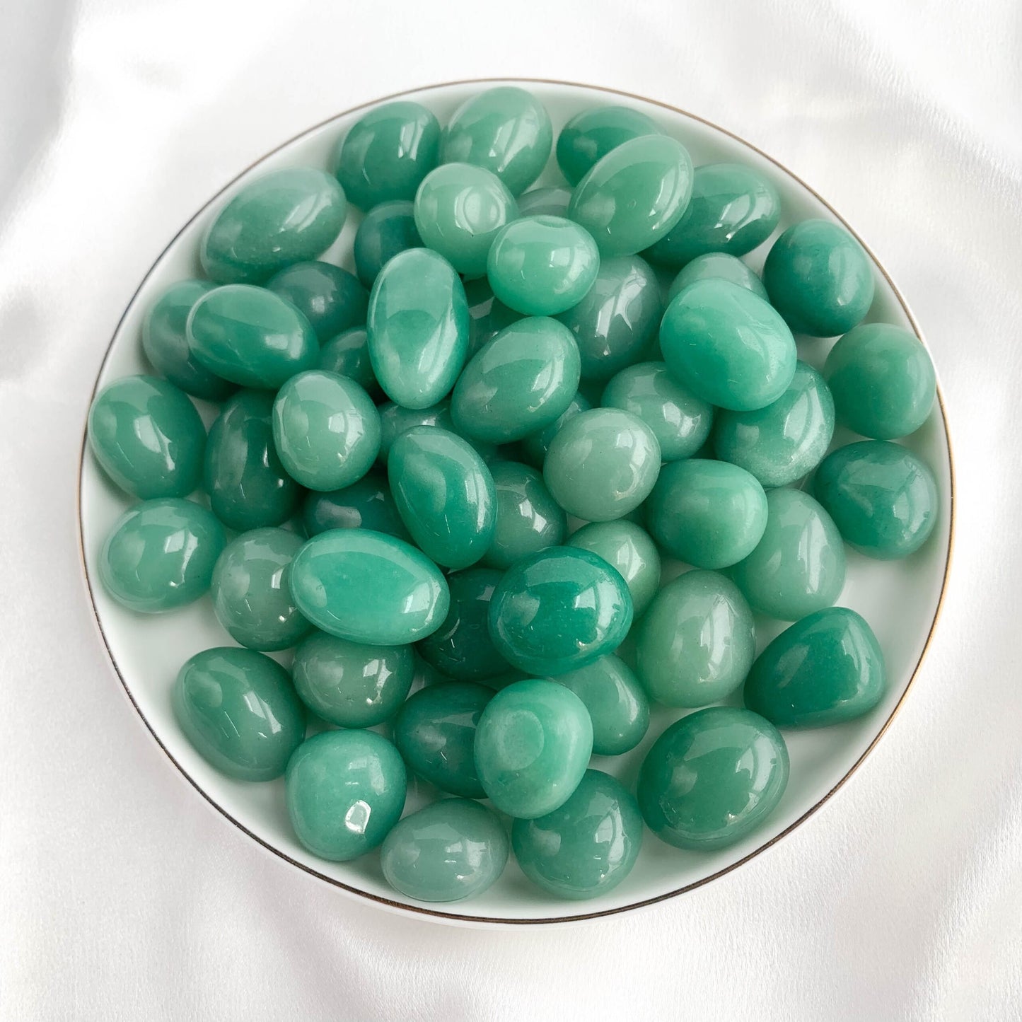 Green Aventurine pocket gems in a bowl, symbolizing luck, prosperity, and emotional balance.