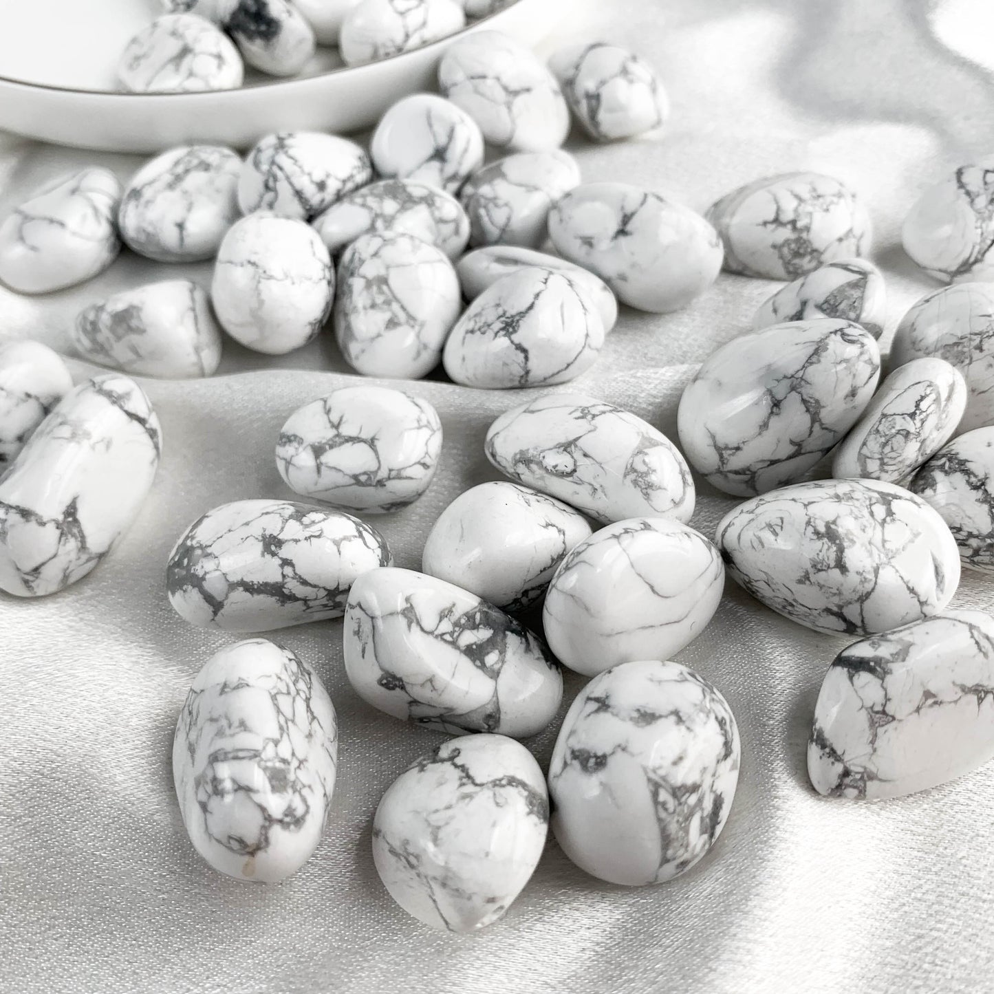 A collection of howlite pocket gems on a soft surface, showcasing their calming patterns and serene colors.
