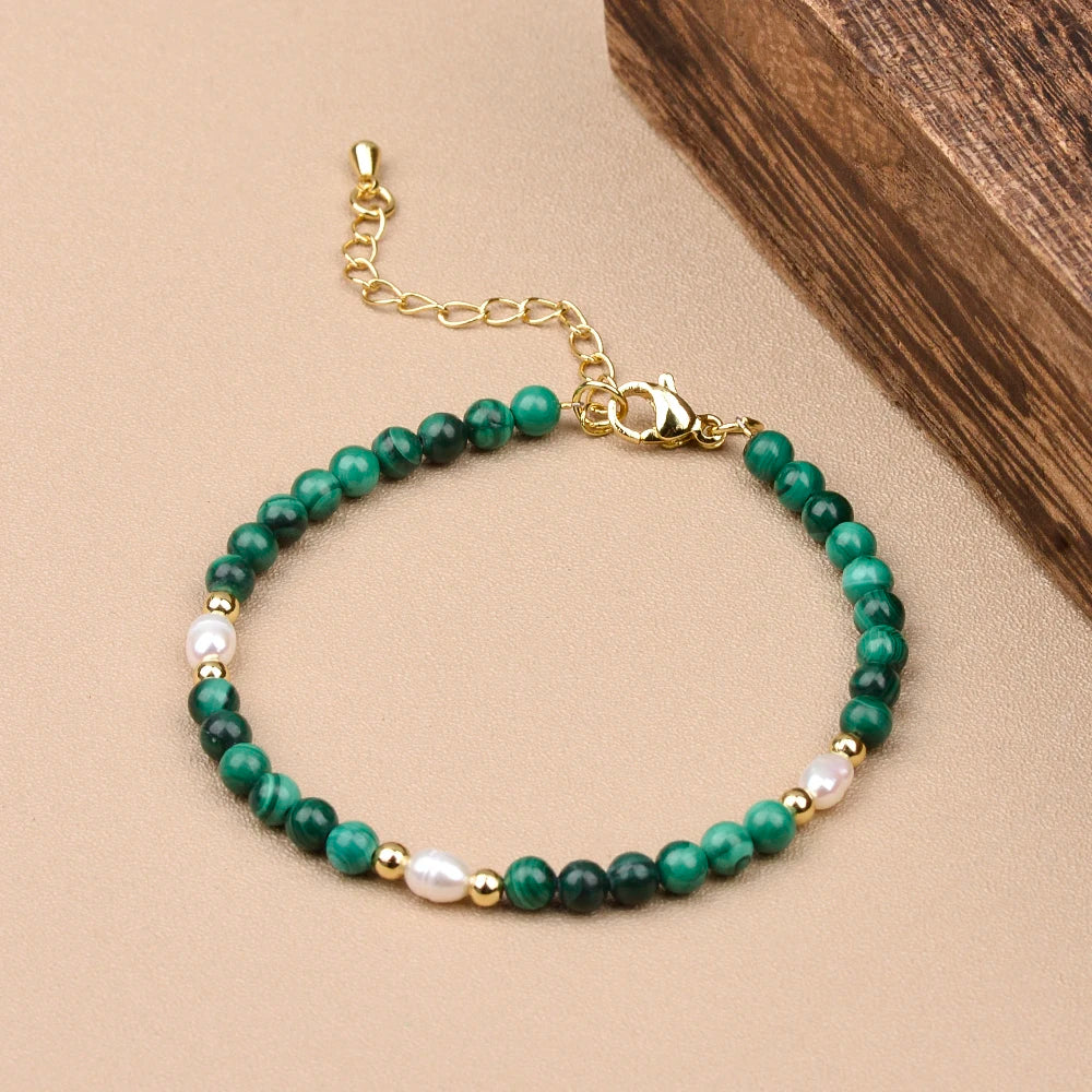 Delicate malachite and pearl bracelet with gold accents, showcasing vibrant green beads and lustrous pearls.