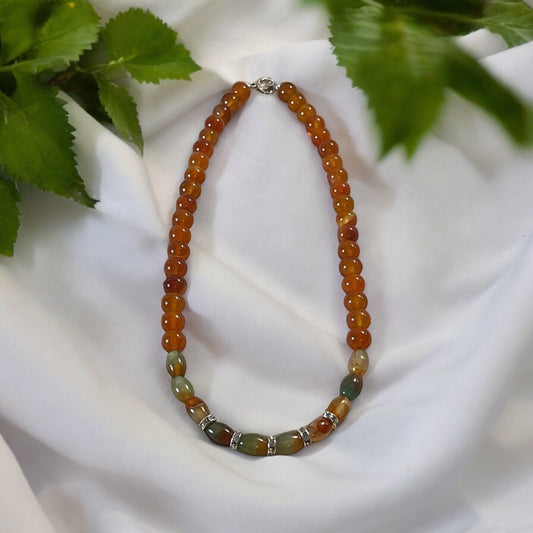 Mystic Heat Carnelian bead necklace with polished round beads and unique oval-shaped stones, accented by silver-toned spacers.