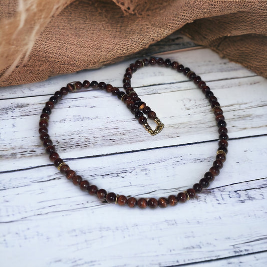 Grounded Passion Red Tiger’s Eye necklace on rustic wooden background, showcasing polished 6mm beads.