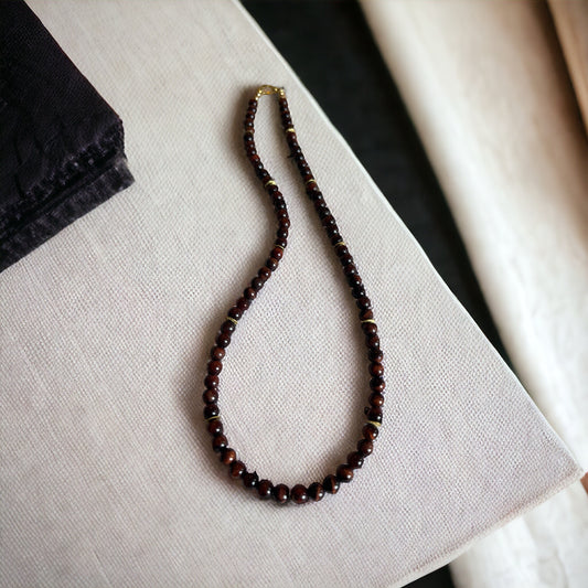 Handcrafted Grounded Passion Red Tiger’s Eye necklace with polished beads displayed on a neutral background.